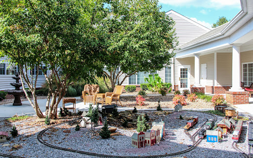 A beautifully landscaped garden featuring comfortable seating, greenery, and decorative elements.