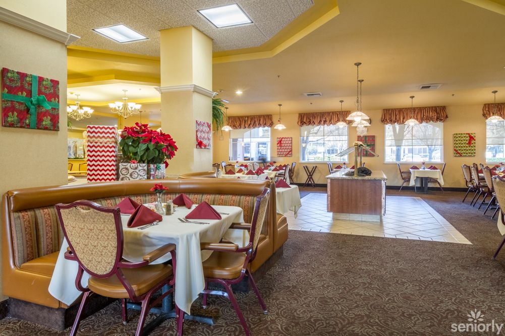 A cozy restaurant interior with neatly arranged tables and chairs, featuring warm lighting and inviting decor.