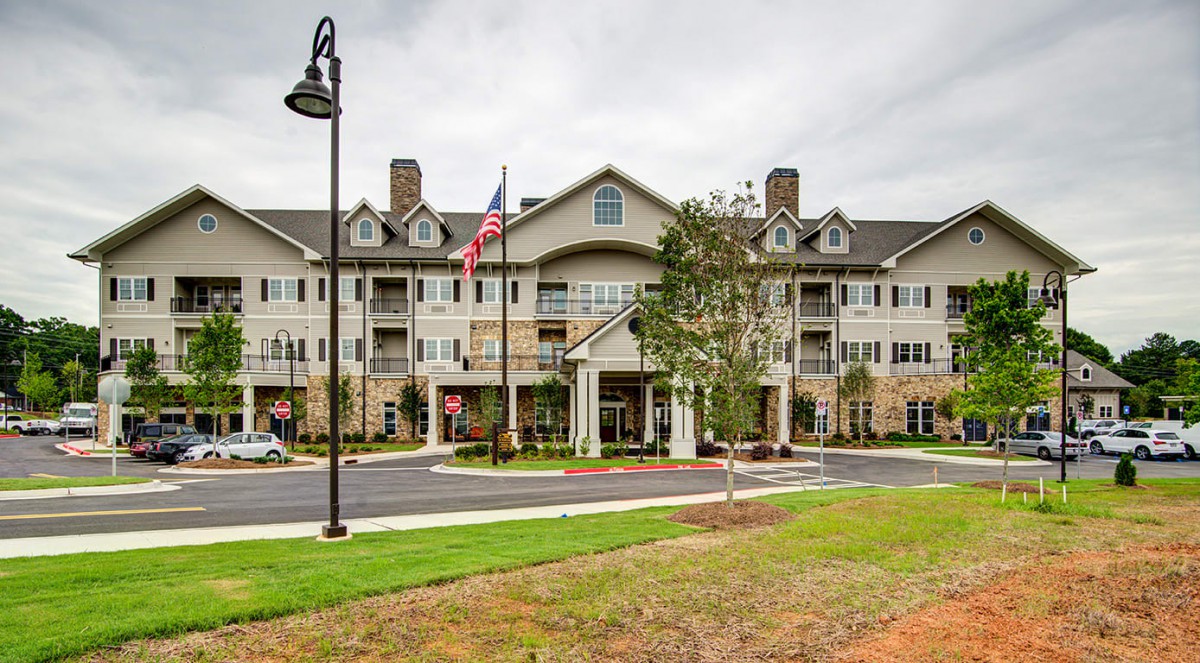 A large residential building with an American flag at the entrance.