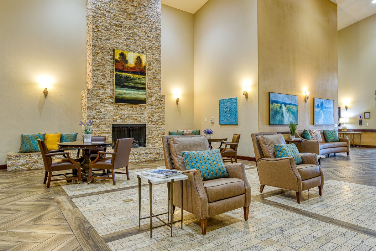 A spacious lobby with comfortable seating, a stone fireplace, and decorative artwork on the walls.