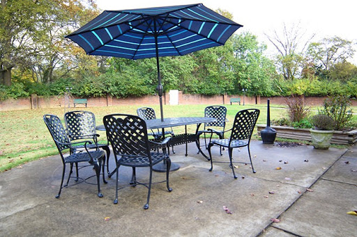A cozy outdoor patio setup featuring a table with chairs and a large umbrella for shade.