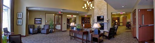A cozy lobby featuring elegant lighting, comfortable seating, and a well-stocked bookshelf.