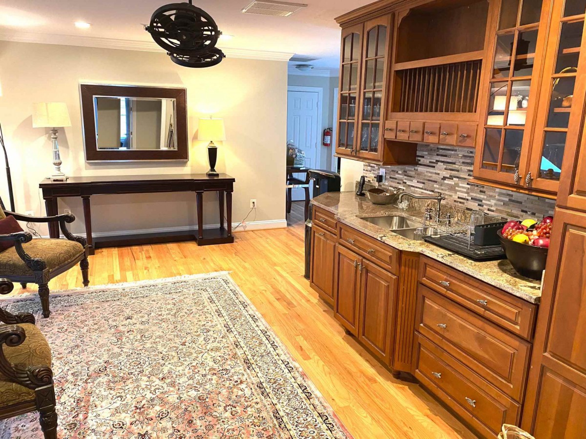 A cozy interior featuring a wooden cabinet, a large area rug, and decorative elements.