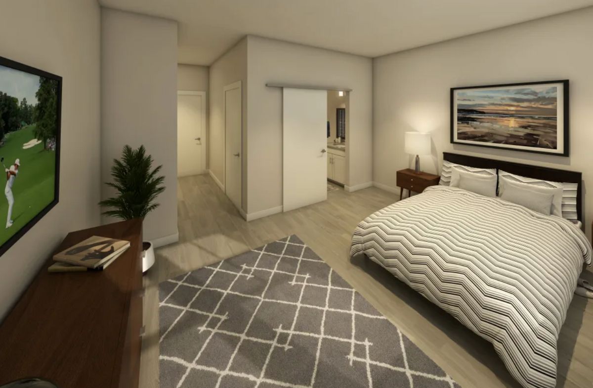 A modern bedroom with stylish decor, featuring a bed, nightstand, and a geometric rug.