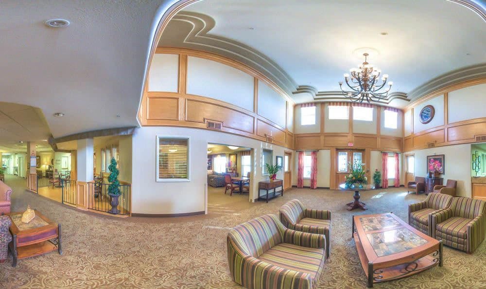 A spacious lobby with modern furniture, a large chandelier, and elegant decor.