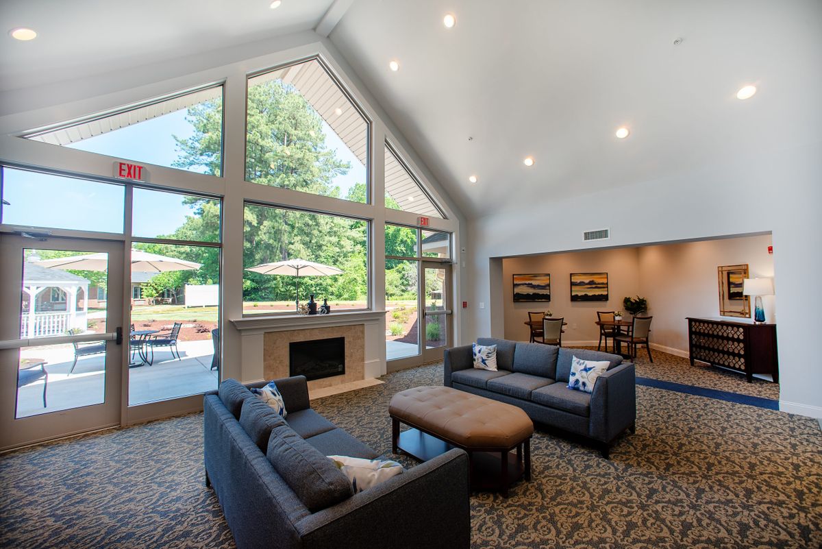 A modern living room with high ceilings, large windows, and contemporary furnishings.