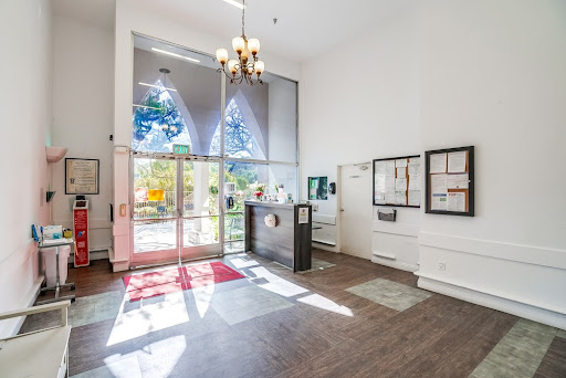 A spacious and bright lobby featuring modern design elements, large windows, and a stylish chandelier.