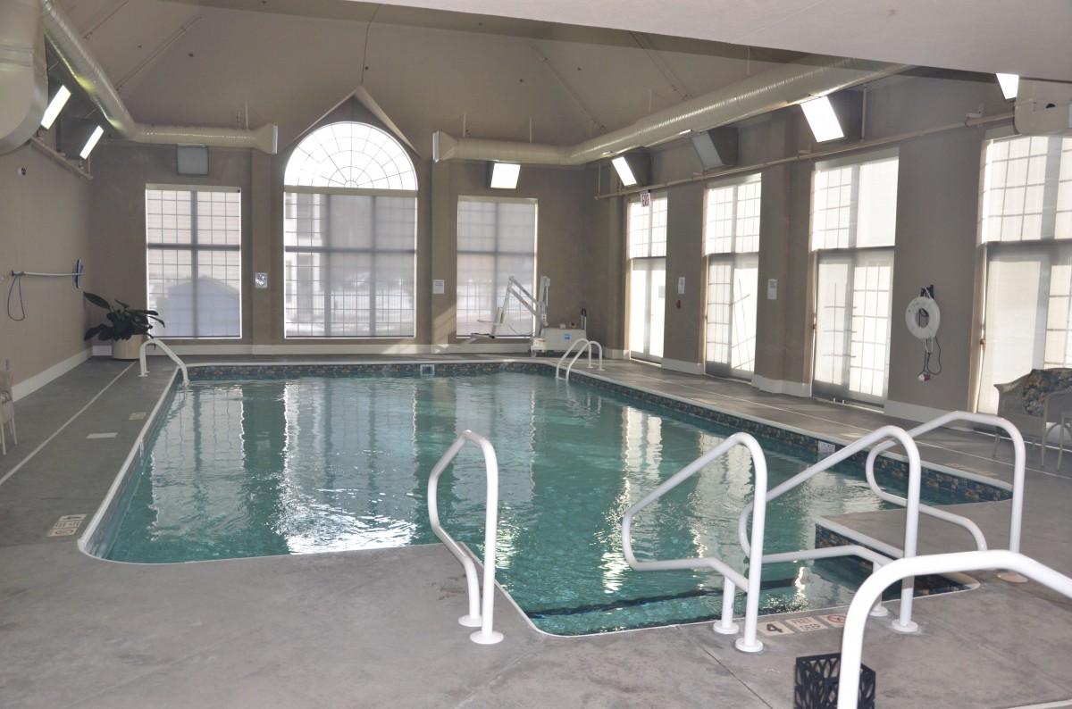 An indoor swimming pool area with large windows providing natural light.