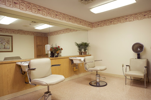 A tidy and organized salon space featuring styling chairs and a large mirror.