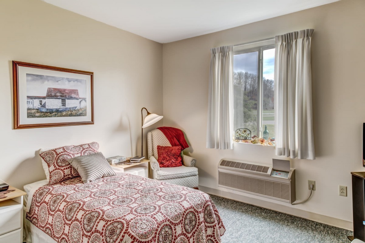 A cozy bedroom with a single bed and a window view.