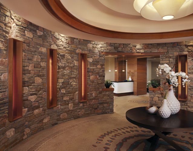 A stylish reception area with stone walls, elegant decor, and modern lighting.