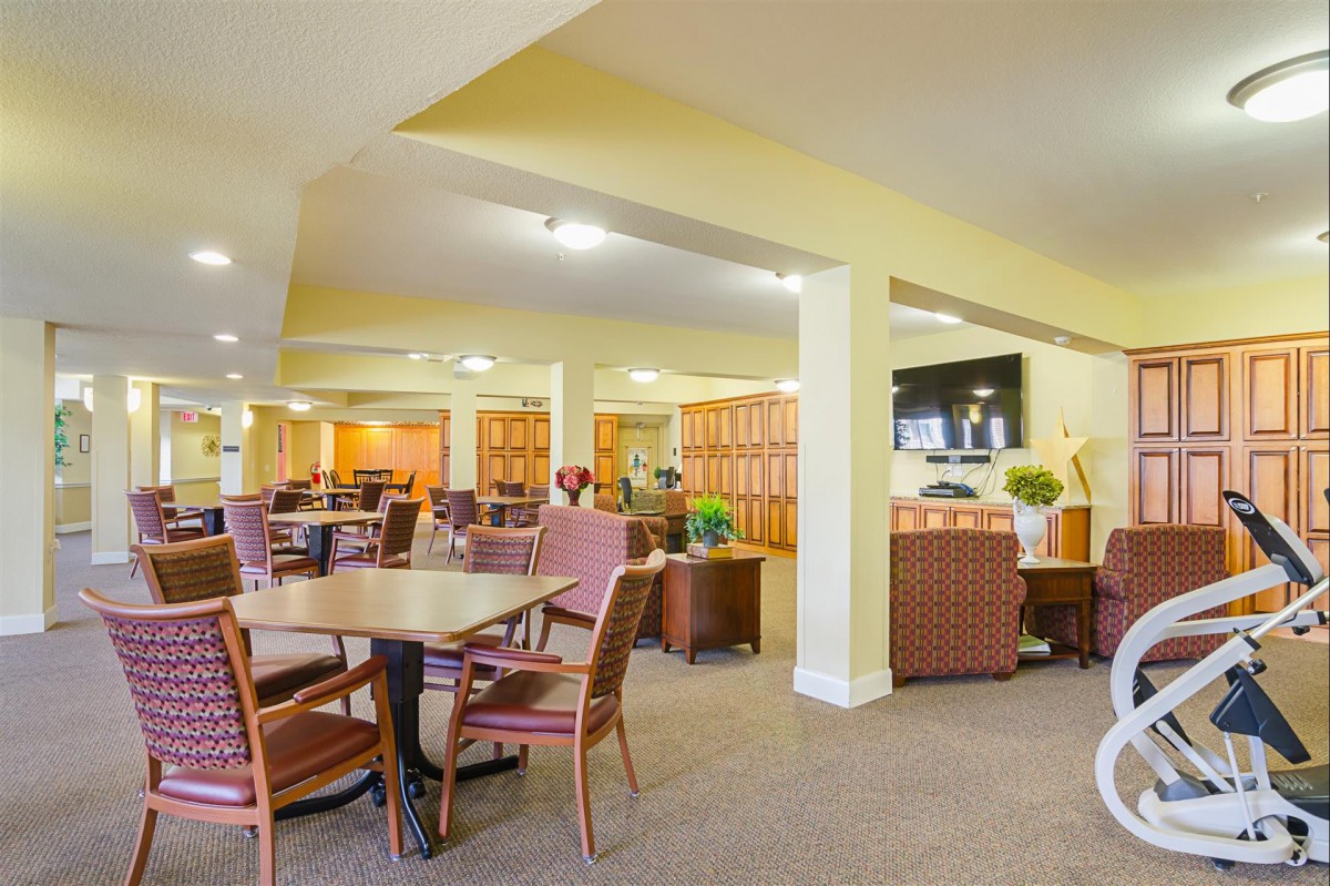 A spacious indoor lounge area with comfortable seating and multiple tables.