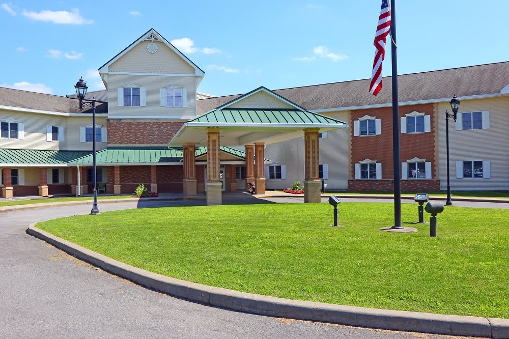A large building with a welcoming entrance and an American flag flying nearby.