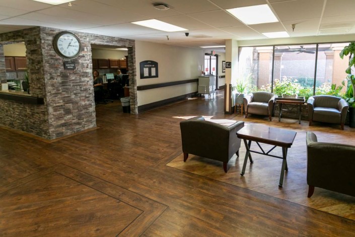 A spacious lobby with seating area and a clock on the wall.