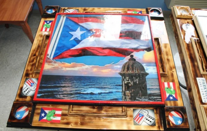 A vibrant artwork depicting the Puerto Rican flag over a coastal landscape with iconic architecture.