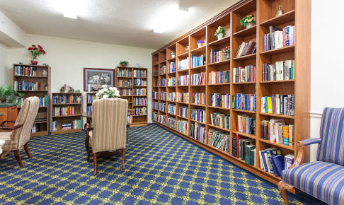 A cozy library room with bookshelves and a comfortable armchair.
