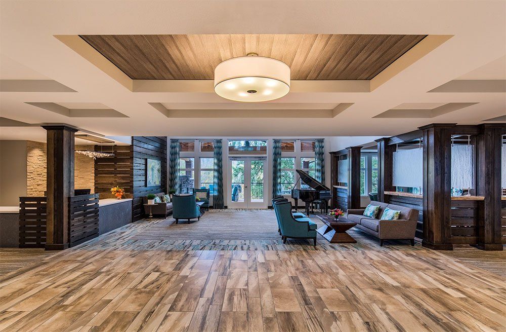 A spacious and modern lobby interior with a seating area and piano.