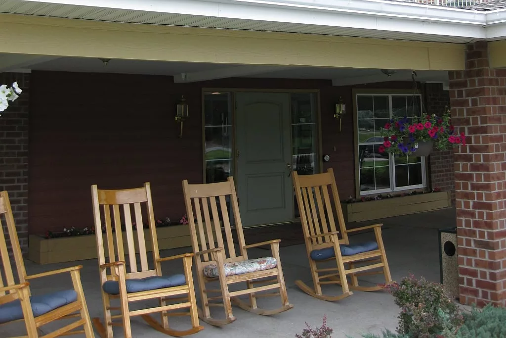 A cozy front porch with wooden rocking chairs invites relaxation.