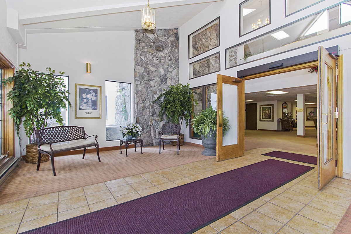 A spacious lobby area with stylish decor, featuring seating and greenery.