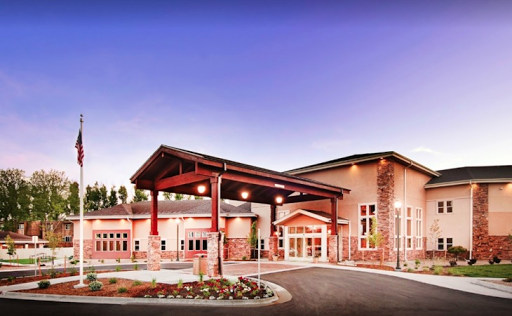 A modern architectural building featuring a welcoming entrance and landscaped surroundings.