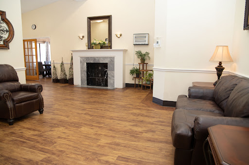 A spacious and inviting living room featuring a fireplace, comfortable seating, and decorative plants.