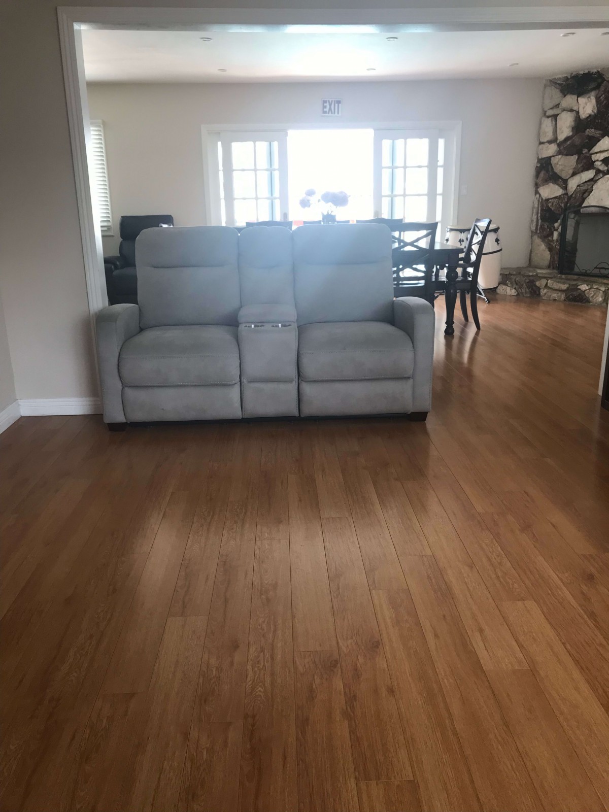A cozy living room with a comfortable sofa and wooden flooring.