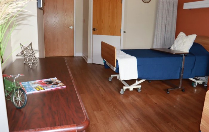 Simple hospital room interior with a bed and table.