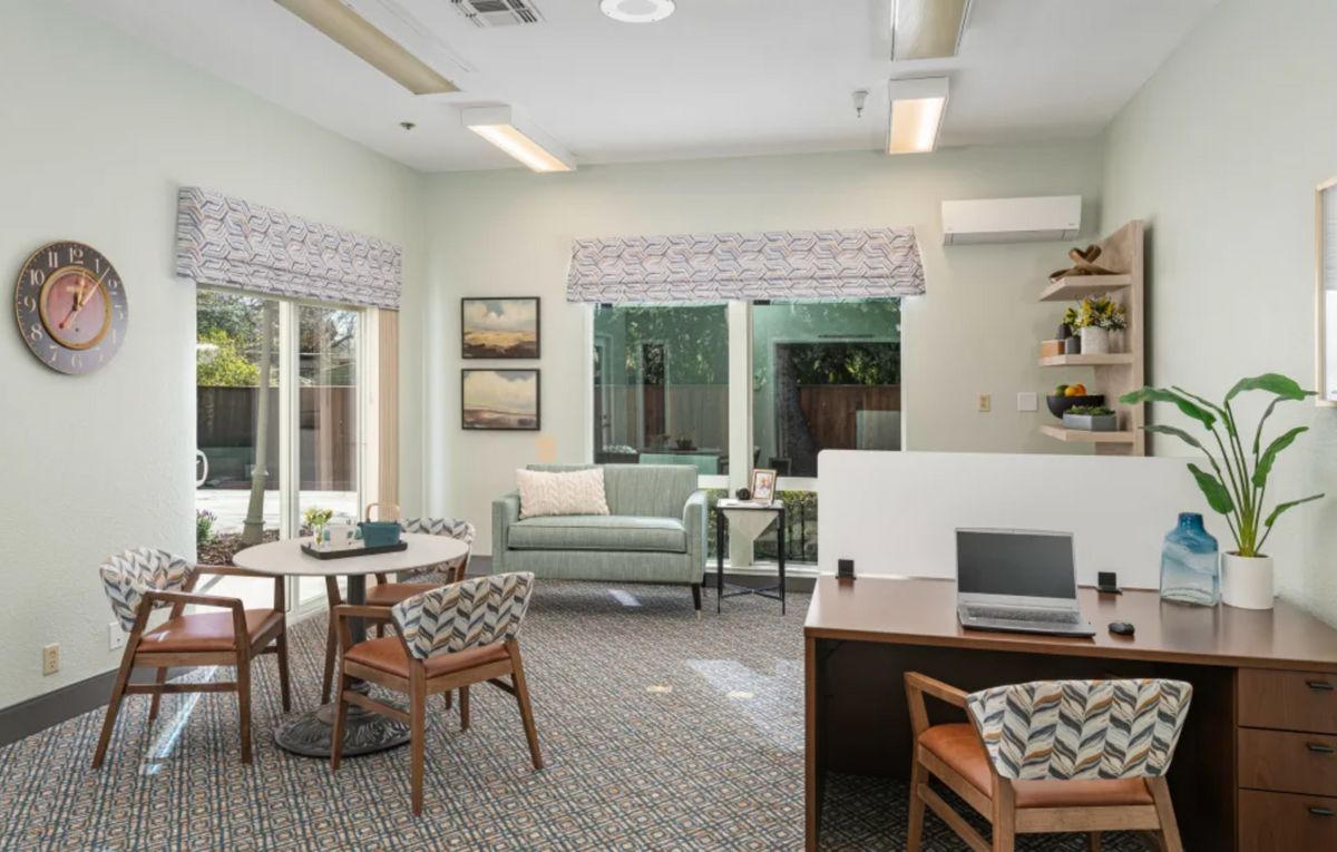A modern living room and office space with stylish furniture and natural lighting.