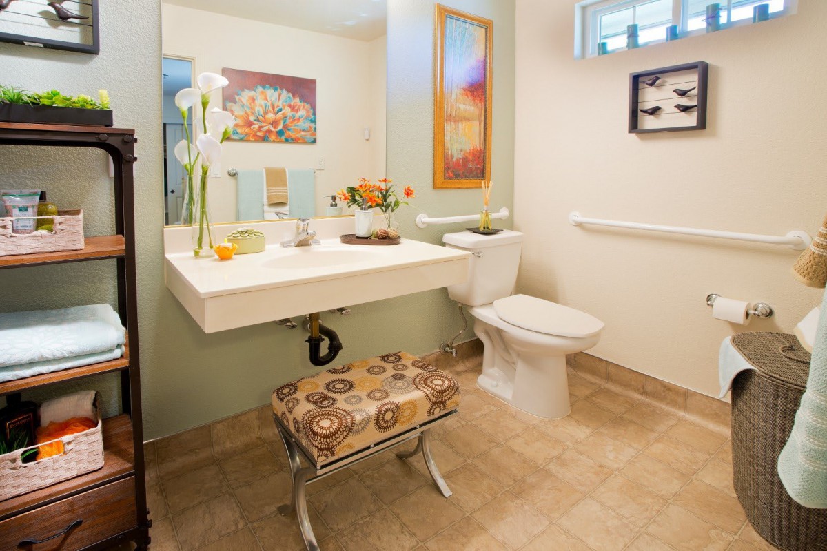 A well-decorated bathroom featuring a sink, toilet, and artwork.