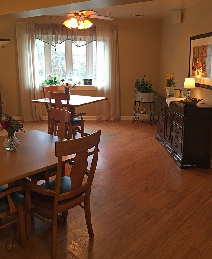 A cozy dining room with wooden furniture and a large window.