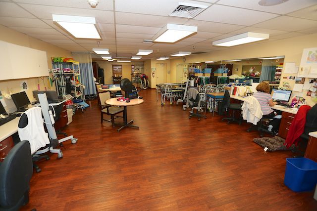 A rehabilitation center featuring a spacious therapy room equipped with various exercise machines.