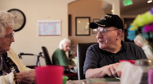 Two seniors enjoying a conversation in a care facility.