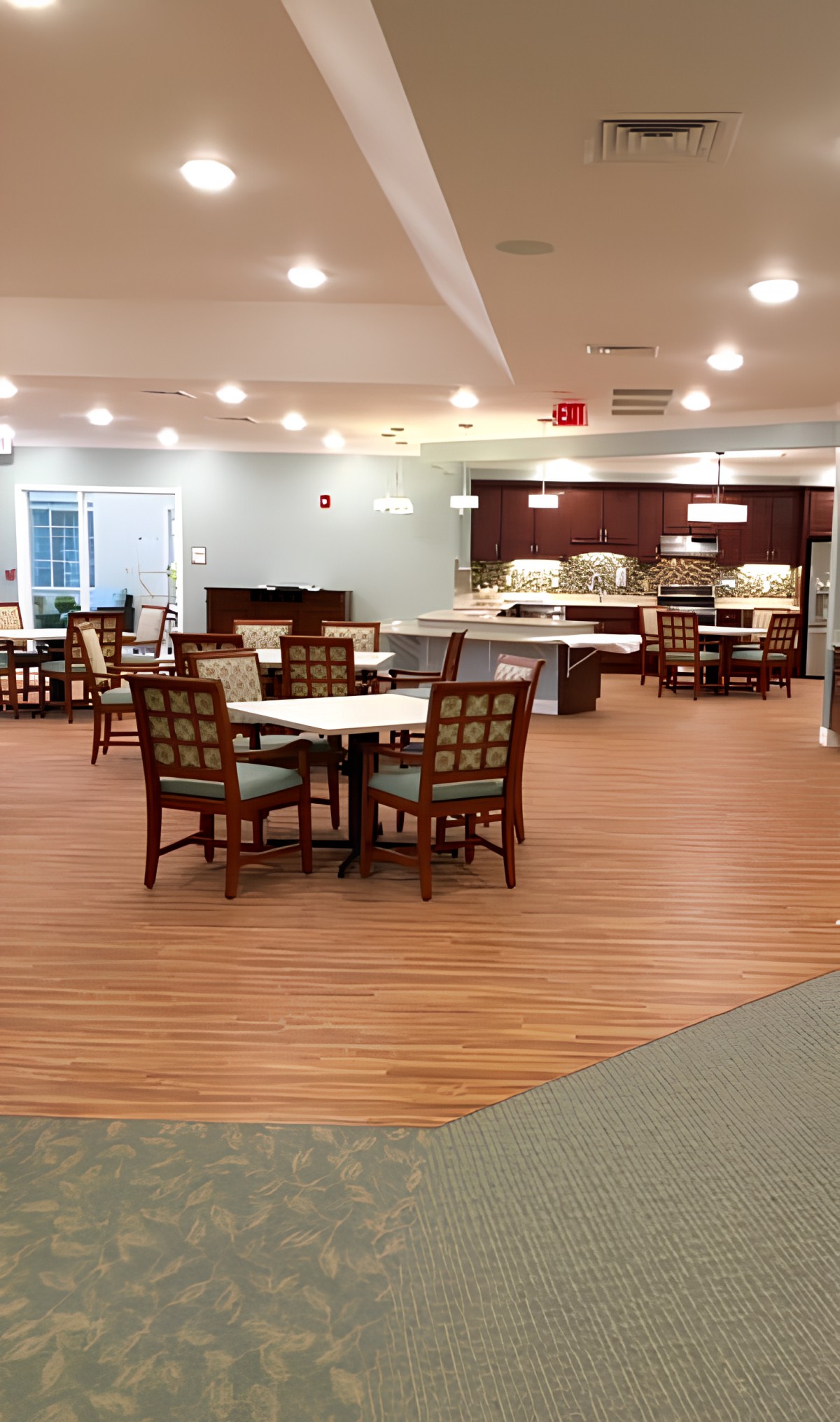 A spacious dining area with neatly arranged tables and chairs under bright lighting.
