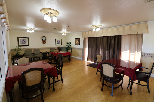 A cozy dining room setting with tables set for meals, featuring comfortable seating and warm lighting.