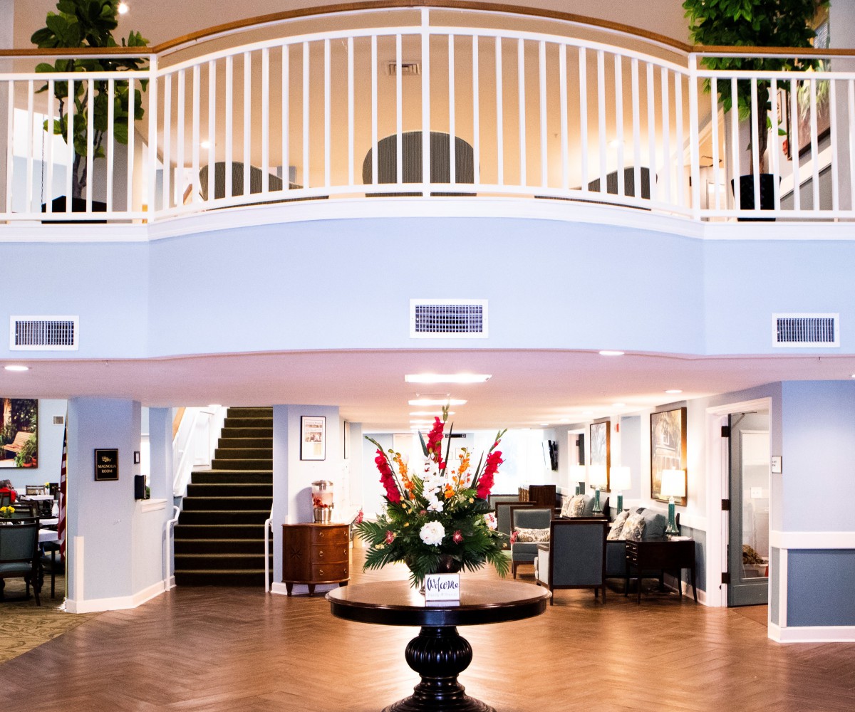 A welcoming hotel lobby with elegant interior design and a central floral arrangement.