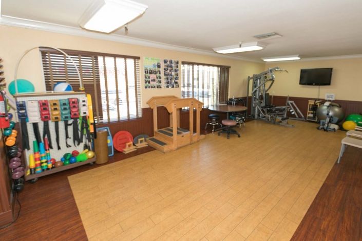 A well-equipped therapy room with various rehabilitation and exercise equipment.