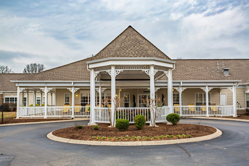 A charming building with a gazebo-style entrance and well-maintained landscaping.