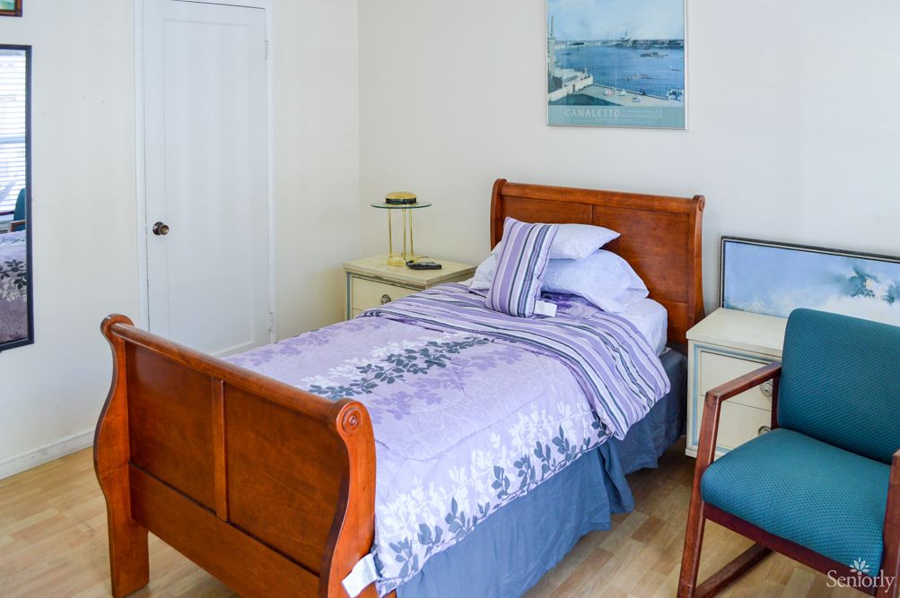 A cozy bedroom with a single bed and wooden furniture.