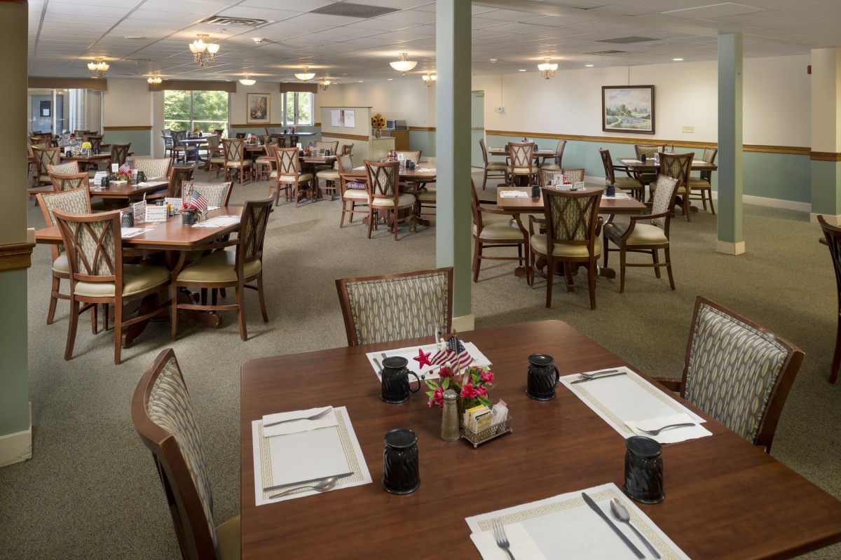 An empty dining area with neatly arranged tables and chairs, ready for guests.