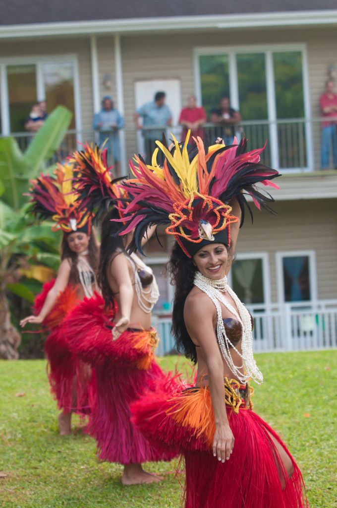 Performers in vibrant traditional attire participate in a cultural dance outdoors.