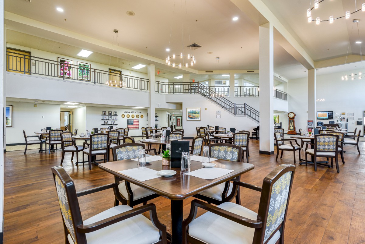 A spacious and modern dining room with neatly arranged tables and chairs.