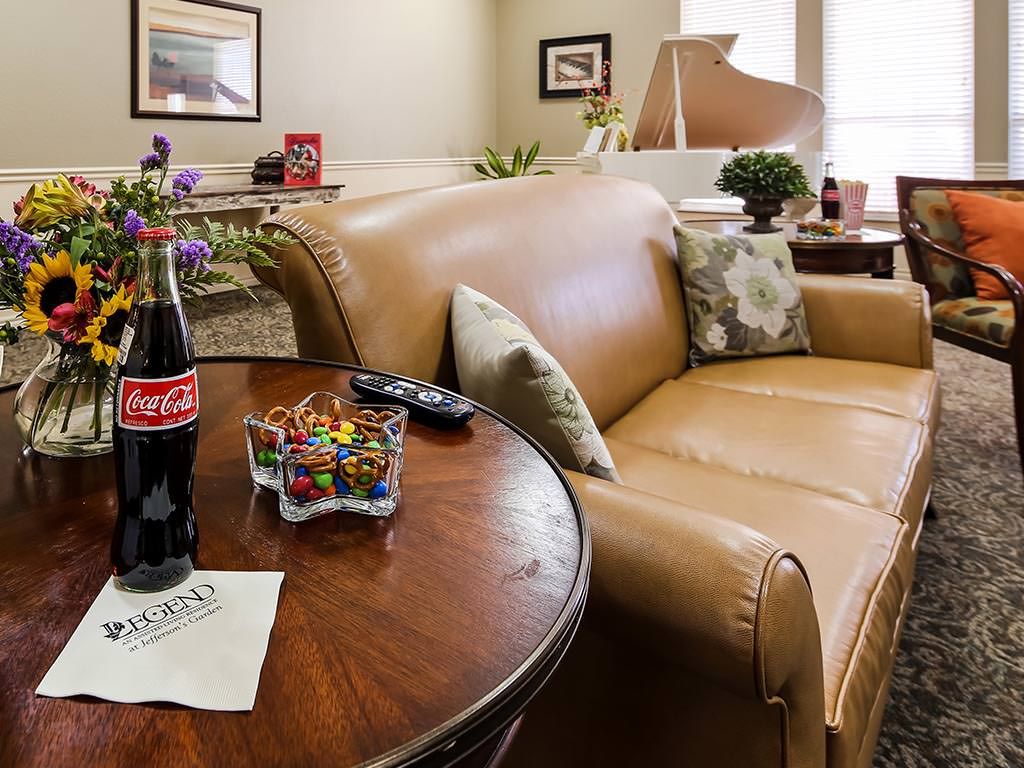 Cozy living room with a sofa, Coca Cola on the table, and a piano in the background.