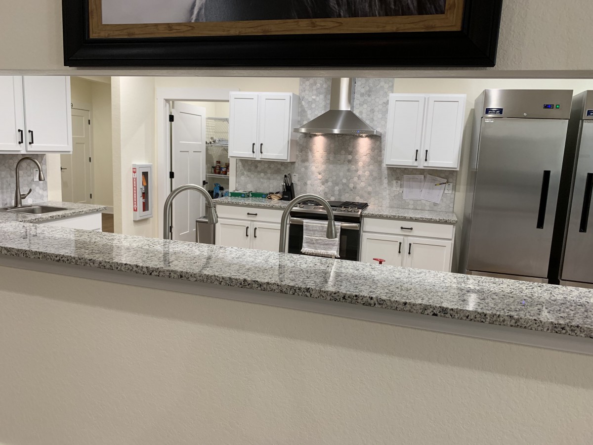 A modern kitchen with white cabinets and stainless steel appliances.