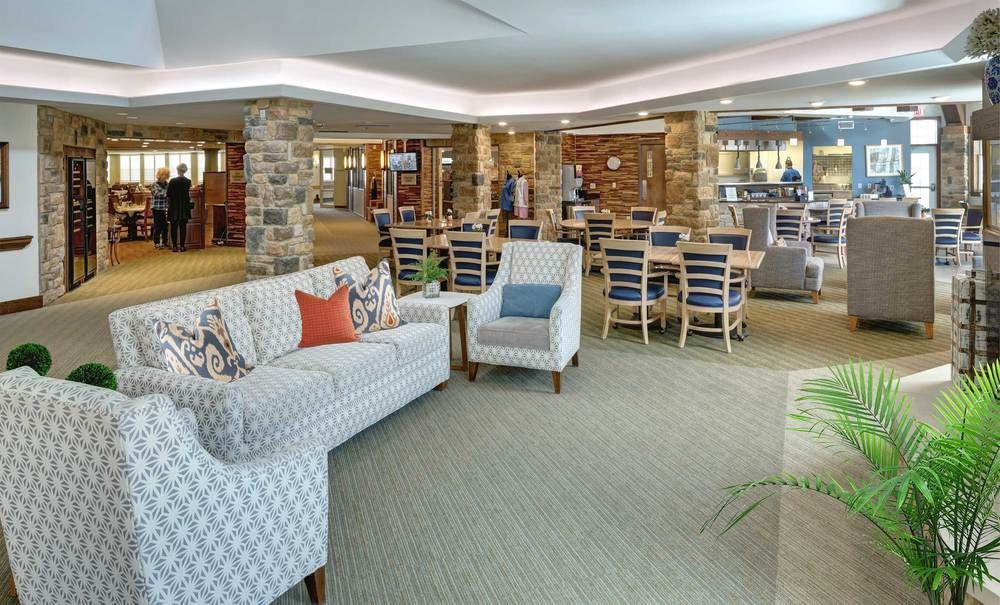 A modern lobby with comfortable seating and a dining area.
