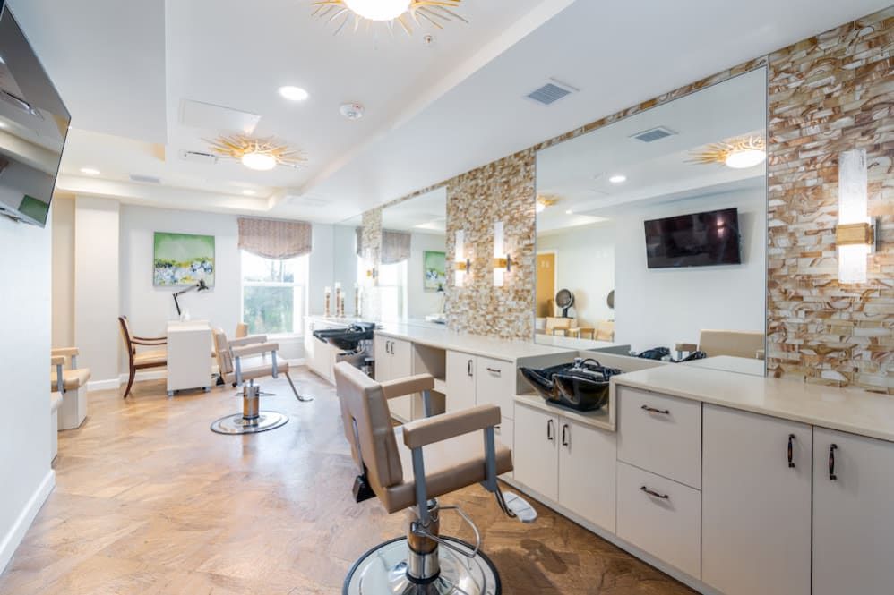 A modern and spacious salon interior with multiple chairs and mirrors.