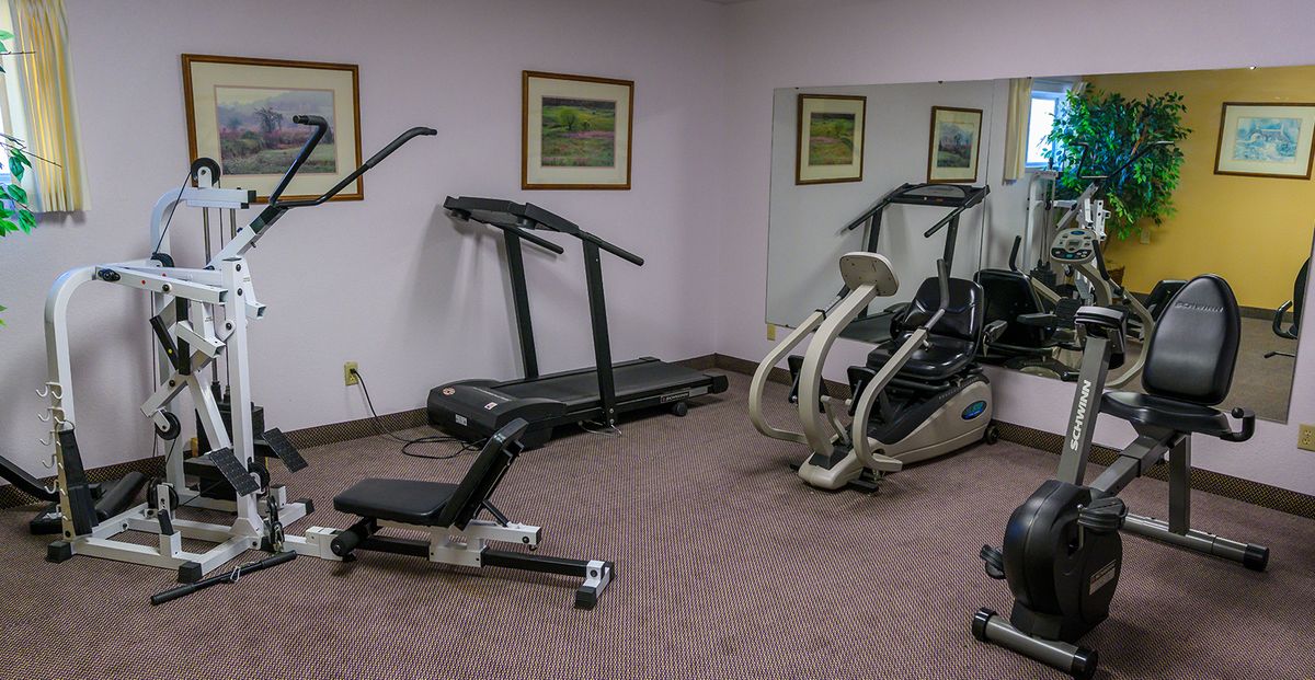 A small gym with exercise equipment including a treadmill and an elliptical machine.