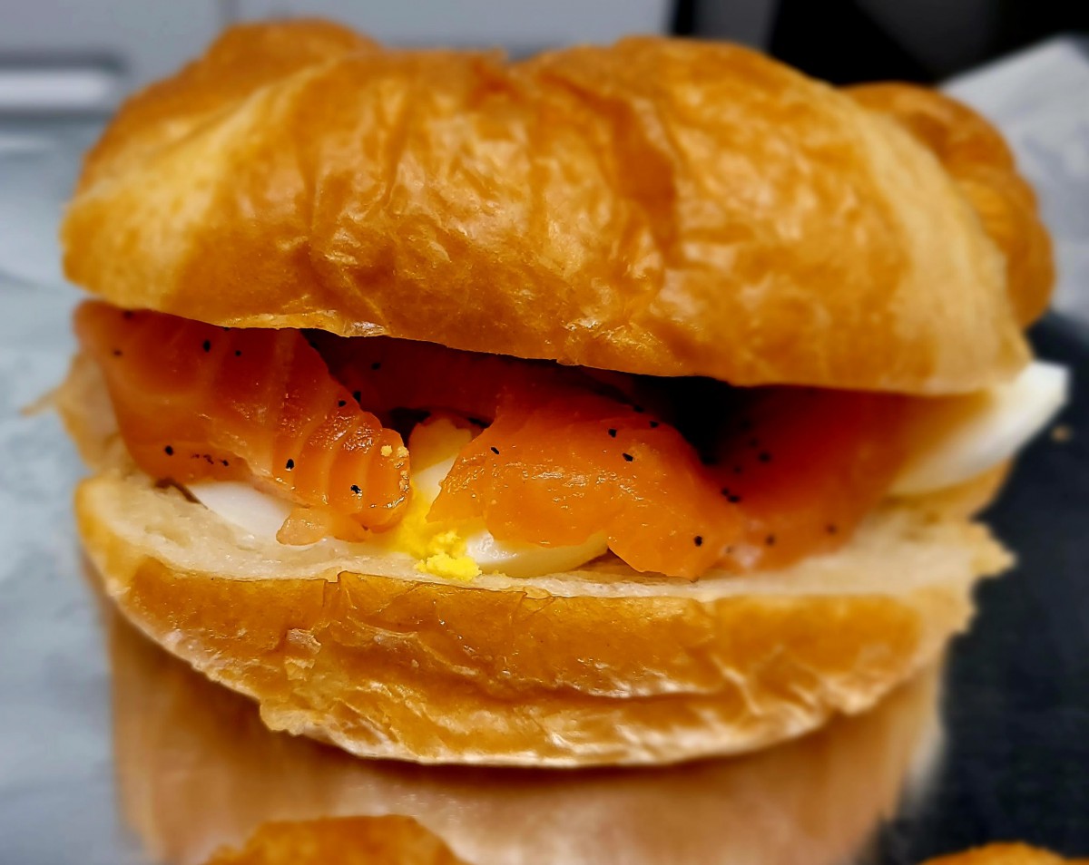 A croissant sandwich filled with smoked salmon, perfect for breakfast.