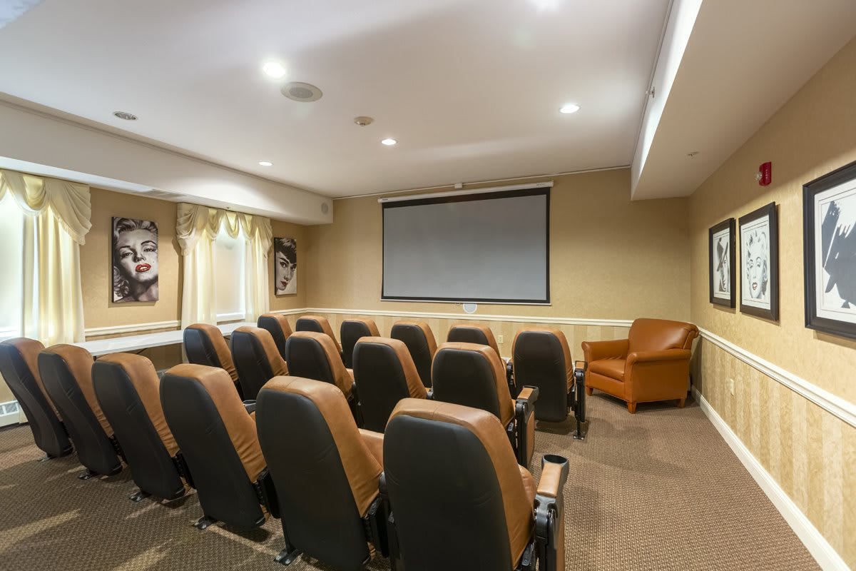 A cozy home theater setup with tiered seating and a large projection screen.