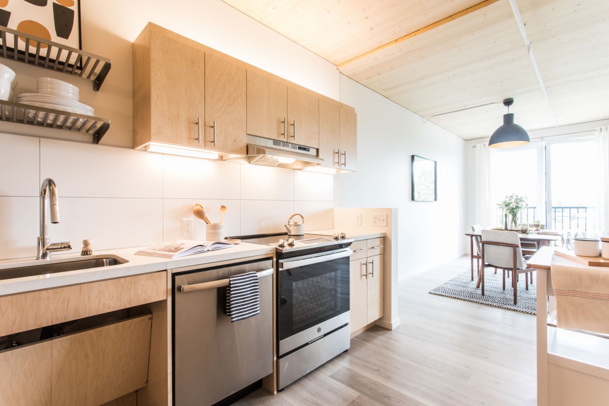 A modern kitchen with wooden cabinets and stainless steel appliances.
