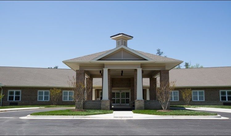A modern building entrance with columns and a large covered roof.